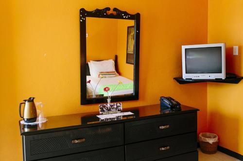 a bedroom with a dresser with a mirror and a tv at Galina Breeze in Port Maria