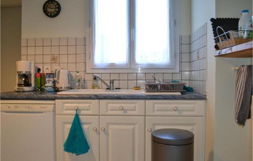 cocina con armarios blancos, fregadero y ventana en Nice Home In Seyresse With Outdoor Swimming Pool, en Seyresse