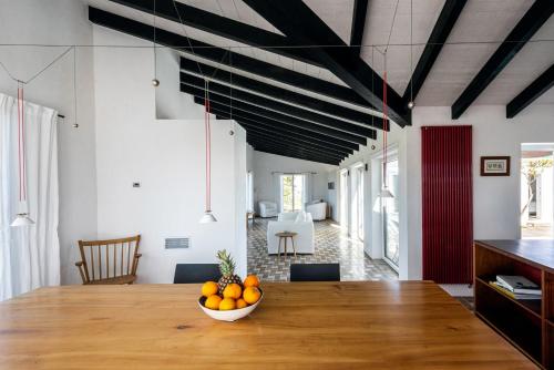 a dining room with a table with a bowl of oranges on it at Sanderling beach & dune house in Carrapateira