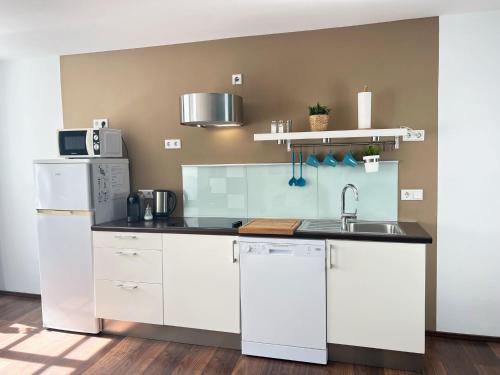 a kitchen with white cabinets and a sink at Ferienwohnungen Lebenswert Ferienwohnung Lebenswert I in Meersburg