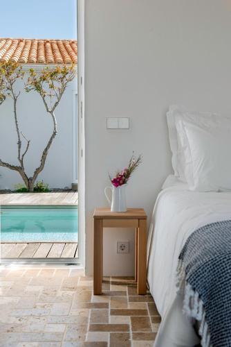 a bedroom with a bed and a view of a pool at Sanderling beach & dune house in Carrapateira