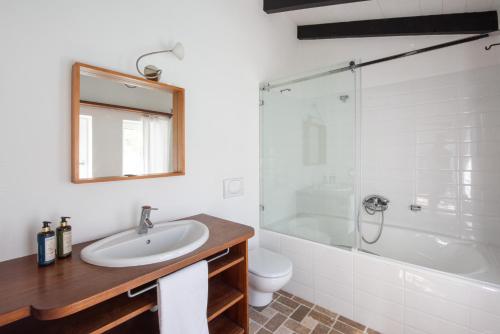 a bathroom with a sink and a shower and a toilet at Sanderling beach & dune house in Carrapateira