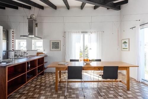 a kitchen with a wooden table and chairs at Sanderling beach & dune house in Carrapateira