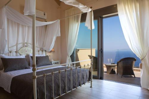 a bedroom with a bed with a view of the ocean at Thea Thalatta Villas in Tsoukaladhes