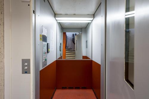 a hallway in a building with an orange floor at Hiisi Homes Helsinki Haaga in Helsinki