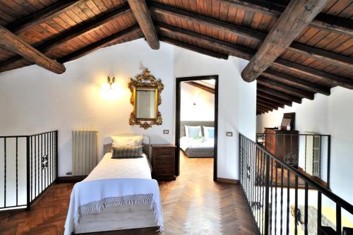 馬斯利尼科的住宿－Stone Cottage Deluxe，卧室配有一张床,墙上设有镜子