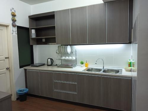 eine Küche mit braunen Schränken und einem Waschbecken in der Unterkunft GS Suite & Homestay in Ipoh