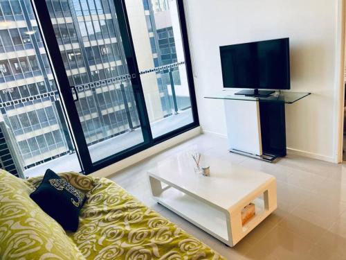 a living room with a couch and a coffee table at Two bedrooms apartment in the heart of Melb CBD in Melbourne