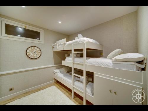 a bedroom with two bunk beds and a clock at TORTUGA de Alma de Nieve in Naut Aran