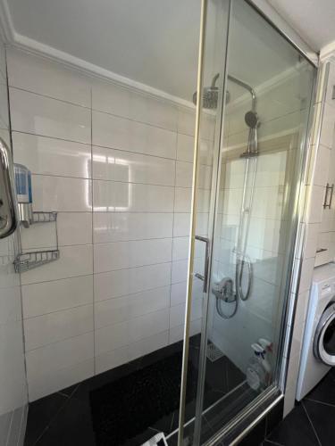 La salle de bains est pourvue d'une douche avec une porte en verre. dans l'établissement Ultra deluxe Villa, à Kyrenia
