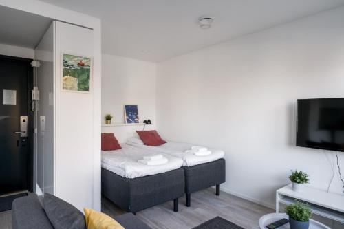 a small room with a bed and a tv at Hiisi Homes Helsinki Haaga in Helsinki