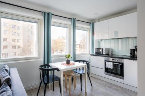 a kitchen with a table and chairs in a room at Hiisi Homes Helsinki Haaga in Helsinki