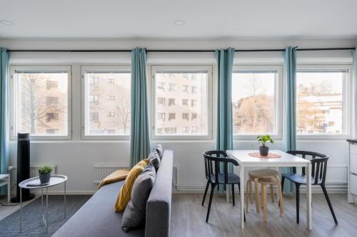 a living room with a couch and a table at Hiisi Homes Helsinki Haaga in Helsinki