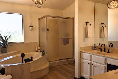 a bathroom with a tub and a shower and a sink at The Arrowhead Oasis - hot tub, heated pool, fire pits, backyard games in Glendale