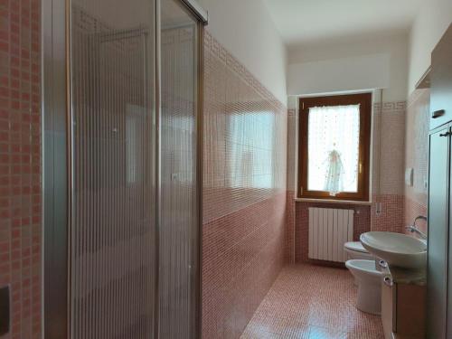 uma casa de banho com um chuveiro, um WC e um lavatório. em Sweet holidays em Matera