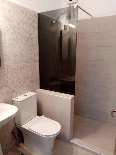 a bathroom with a toilet and a tub and a sink at Deaspoina Apartments in Nea Roda