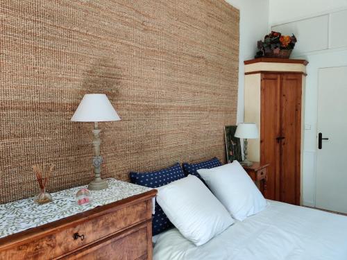 a bedroom with a bed and a brick wall at Le Cerisier in Mareil-Marly
