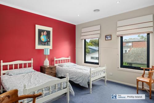 two beds in a bedroom with red walls at 29 Church Street, Cowes in Cowes