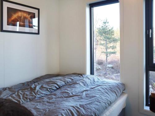 sypialnia z łóżkiem przed oknem w obiekcie Holiday home Søndeled w mieście Søndeled