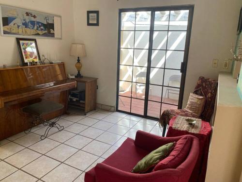 sala de estar con sofá y piano en Casa Gaviotas Art cozy 2 bed house with art studio close to downtown, en La Paz