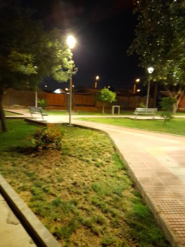 un parc la nuit avec un banc et un éclairage de rue dans l'établissement Departamento Ciudad del Encanto, à Ovalle