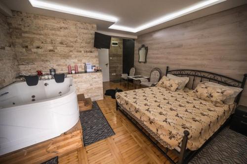 sypialnia z łóżkiem i wanną w obiekcie Onore dell’amore w mieście Banja Koviljača