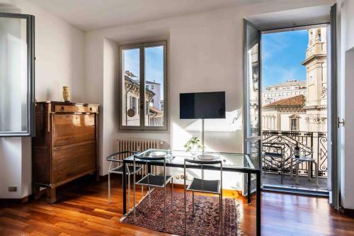 una stanza con un tavolo di vetro e una grande finestra di [DUOMO 2 MINUTI A PIEDI] Vista mozzafiato 5 stelle a Milano
