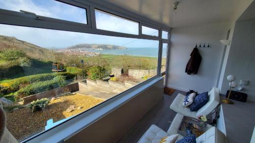 a room with a large window with a view at A View With A Room in Penrhyn Bay