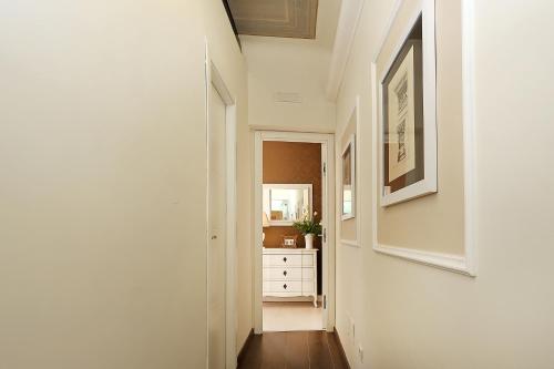 a hallway with a white wall and a mirror at Daplace - HQH Colosseo in Rome