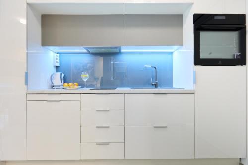 una cocina con armarios blancos y una pared azul en Hedera Estate, Hedera Studio 4, en Dubrovnik