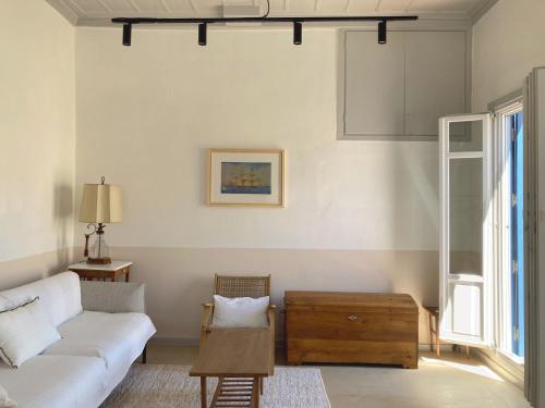 uma sala de estar com um sofá e uma mesa em Giasemi house with sea view em Panormos