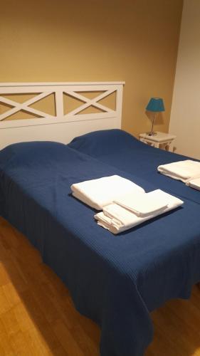 a blue bed with two white towels on it at Résidence Mes Amours d'Enfants - Les Villas du Lac in Soustons