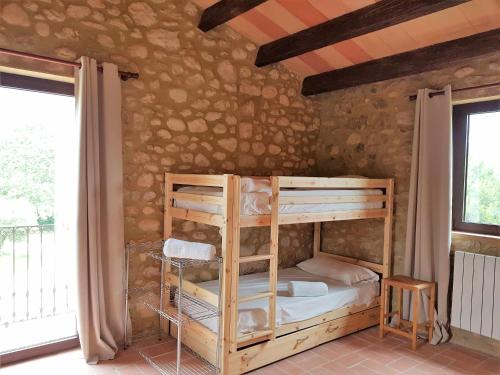 Giường trong phòng chung tại Masía restaurada con piscina privada-28 pax