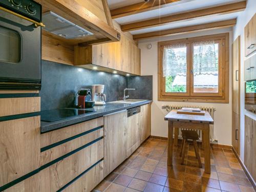 une cuisine avec des armoires en bois et une table à l'intérieur dans l'établissement Bel appartement 3 ch, calme, garage, Wifi - FR-1-437-18, à La Clusaz