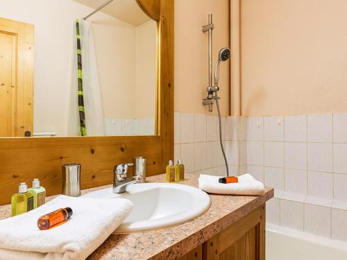 une salle de bain avec un lavabo, un miroir et une baignoire dans l'établissement Appartement familial au pied des pistes, 3 chambres, 2 salles de bain, garage - Proche village - FR-1-437-34, à La Clusaz