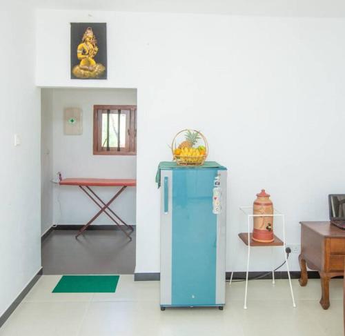 a blue refrigerator in a room with a table at Greenway Apartment in Galle