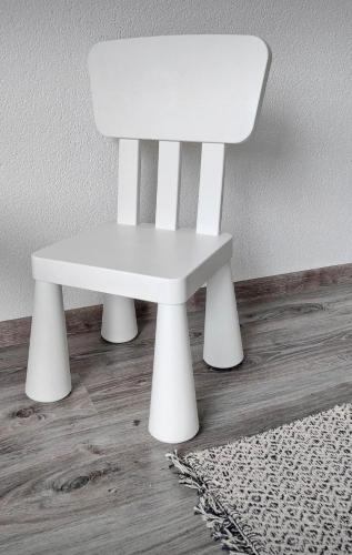 a white chair sitting on top of a wooden floor at Ive Andrica 3 in Višegrad