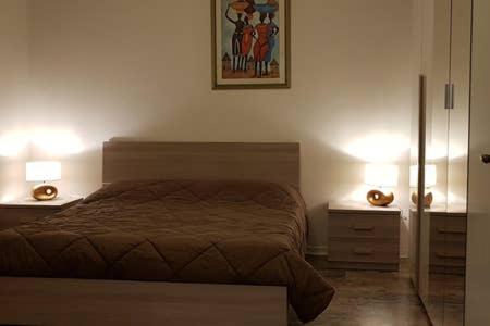 - une chambre avec un lit et 2 tables de nuit avec des lampes dans l'établissement Civico 26, à Cattolica