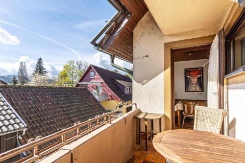 a balcony with a wooden table and a table at Hirschturmblick in Zell am Harmersbach