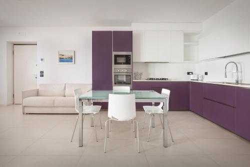 een keuken met paarse kasten en een tafel en stoelen bij Villa Oleandri in San Pietro in Cariano