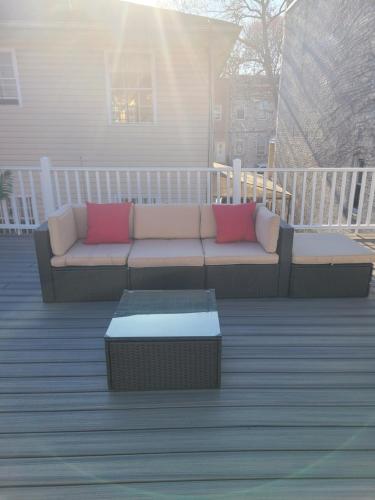 eine Couch auf einer Terrasse mit Couchtisch in der Unterkunft Exquisite in Brooklyn