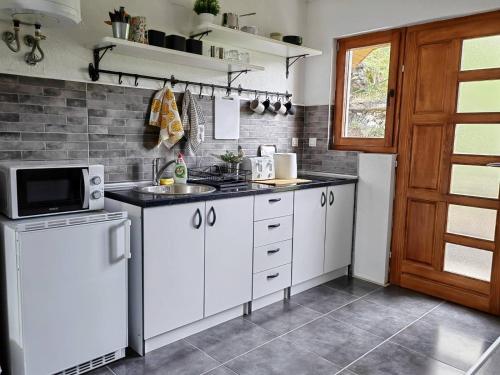 a kitchen with white cabinets and a microwave at Ive Andrica 3 in Višegrad