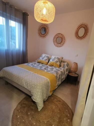 une chambre avec un lit et deux miroirs au mur dans l'établissement Chez Baptiste et Laura, à Figari