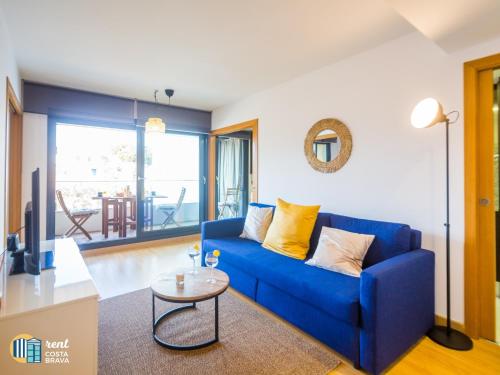 uma sala de estar com um sofá azul e uma mesa em Apto Diana em Platja d'Aro