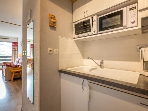 une cuisine avec un évier et un micro-ondes dans l'établissement Studio plein sud avec balcon, 2-4 pers, La Clusaz - FR-1-437-6, à La Clusaz