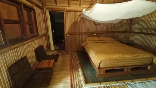 a bedroom with a bed and a chair in it at Bamboo Hideaway, Bungalows with Pool and Kitchen in Ko Mak