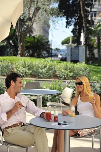 a man and woman sitting at a table with drinks at Résidence Residéal Premium Cannes in Cannes