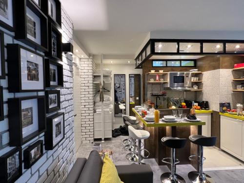 - une cuisine avec un bar et quelques tabourets dans l'établissement Appartement Flandre, à Paris