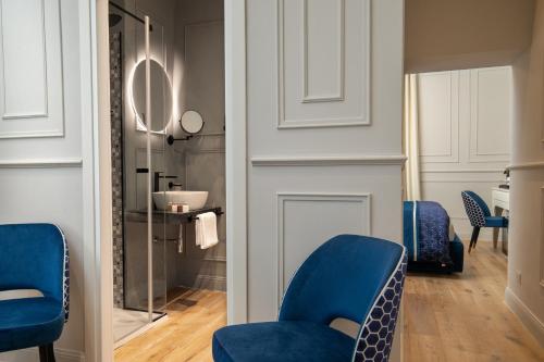 uma sala de estar com cadeiras azuis e um espelho em Navona Sky Palace em Roma
