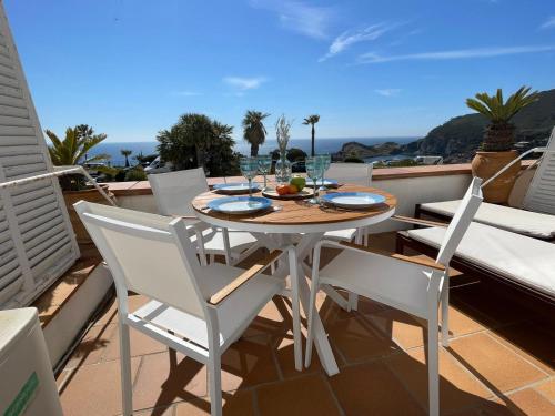 a table and chairs on a balcony with a view of the ocean at Cap Sa Sal - Sa Roca 1 - Studio acceso directo al mar in Begur